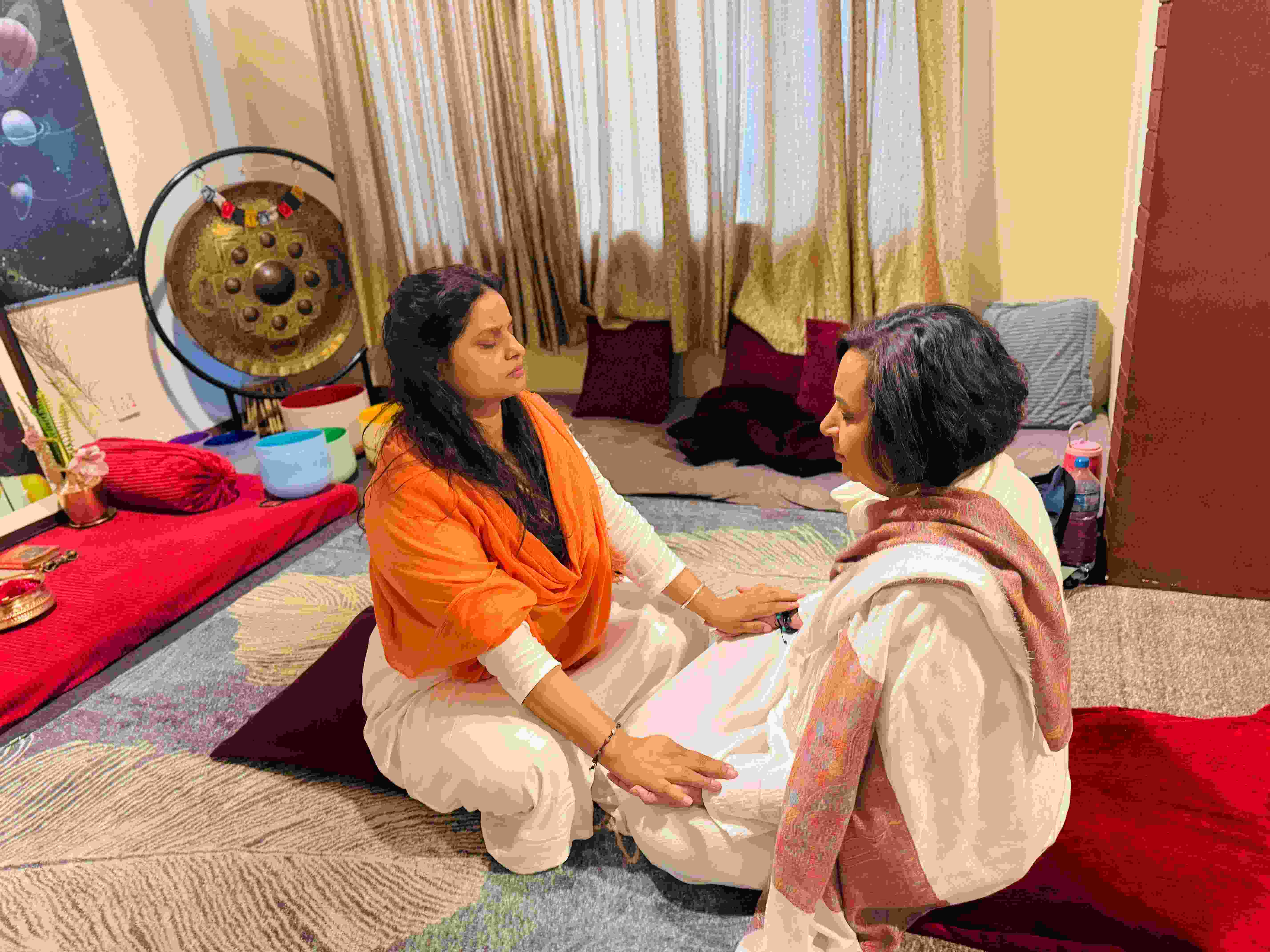 Singing bowl sound healing session at Jivan Parivartan, guests resting under blankets